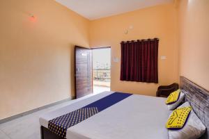 a bedroom with a bed and a window at SPOT ON Hotel Pragya 5 in Raipur