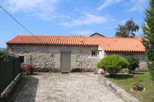 a stone house with a red roof at Casa Maria da Assunção in Vila Nova de Cerveira