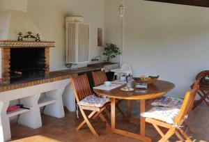 a kitchen with a table and chairs and a fireplace at Cozy cottage with private pool , BBQ & Free Wifi in Pollença