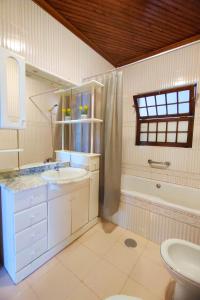 een badkamer met een wastafel, een toilet en een bad bij Vila Almeida in Ponta Delgada