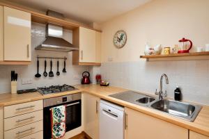 a kitchen with a sink and a stove top oven at Finest Retreats - Hardie Close in Tetbury