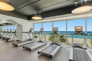 una fila de cintas de correr en un gimnasio con vistas al océano en Beachfront Oasis at Splash Resort and Condos en Panama City Beach