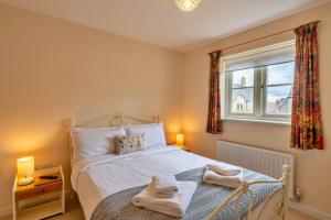 a bedroom with a bed with towels on it at Finest Retreats - Hardie Close in Tetbury