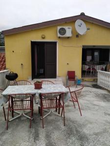 a table and chairs in front of a yellow building at Ivan in Starigrad-Paklenica