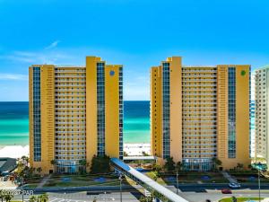 un gran edificio amarillo con el océano en el fondo en Beachfront Oasis at Splash Resort and Condos en Panama City Beach