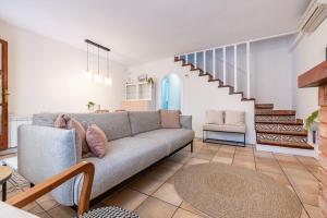 - un salon avec un canapé et un escalier dans l'établissement Preciosa casa al lado del mar, à Creixell