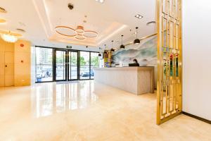 a lobby with a person sitting at a counter at Shanshui Trends Hotel Pazhou International Exhibition Center Branch in Guangzhou