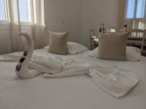 a white bed with a stuffed swan on it at Cute apartments in Kefalos
