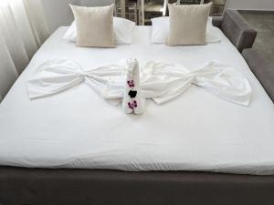 - un lit avec des draps blancs et des arcs dans l'établissement Cute apartments, à Kefalos