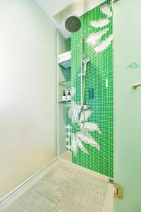 a bathroom with a shower with green tiles at Shanshui Trends Hotel Pazhou International Exhibition Center Branch in Guangzhou +107 photos