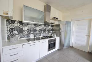 a white kitchen with a sink and a stove at Marco' s apartment in San Vincenzo