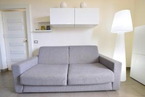 a gray couch in a living room with a lamp at Marco' s apartment in San Vincenzo