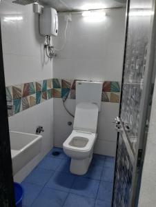a bathroom with a toilet and a bath tub at Bapuji Paying Guest Santacruz West in Mumbai
