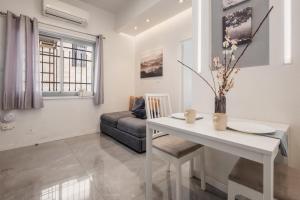 a living room with a white table and a couch at dining room, bedroom and balcony in Jerusalem