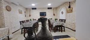 a restaurant with tables and chairs in a room at Boutique Hotel Breshim in Bukhara