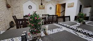 a dining room with two tables with flowers on them at Boutique Hotel Breshim in Bukhara