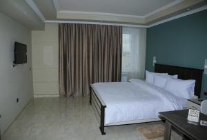 a bedroom with a large white bed and a window at Vell Grey Hotel in Martuni