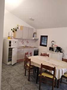 a kitchen with a table and chairs and a kitchen with white cabinets at Ivan in Starigrad-Paklenica