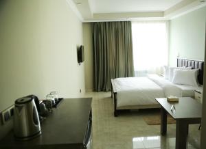 Martuni的住宿－Vell Grey Hotel，酒店客房配有一张床铺和一张桌子。
