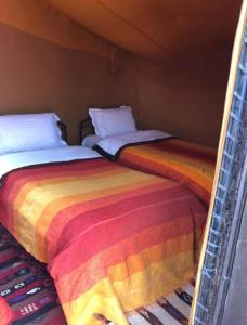 two beds sitting next to each other in a room at Desert Berber Camp in Merzouga