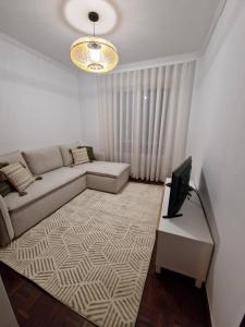 a living room with a couch and a television at Wild Blue By SVL in Ponta Delgada