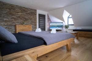 een slaapkamer met een groot bed en een flatscreen-tv bij Liptovský mlyn in Bešeňová