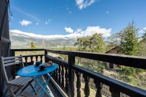 un tavolo su un balcone con vista sulle montagne di Le Mas des Vigne - Jardin - Barbecue - Brasero a Uvernet