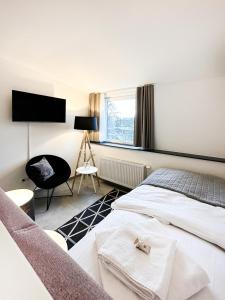 een slaapkamer met een bed en een tv aan de muur bij SI-View Einzelzimmer Zimmer 25 in Siegen