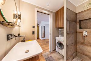 a bathroom with a sink and a washing machine at J N Appartement Spritzenhaus in Sarntal