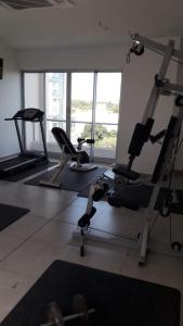 - une salle de sport avec plusieurs tapis de course et machines dans l'établissement Amplio y Super Equipado Studio en Villa Morra, à Asuncion