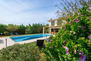 ein Haus mit Pool und ein paar Blumen in der Unterkunft Villa Anassa Privat Pool Near Beach in Klorakas