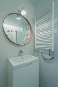 a white bathroom with a sink and a mirror at Apartment Gdynia Centrum SEA 5 min do morza in Gdynia