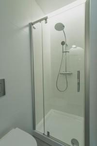 格地尼亞的住宿－Apartment Gdynia Centrum SEA 5 min do morza，一间带卫生间的浴室内的玻璃淋浴间