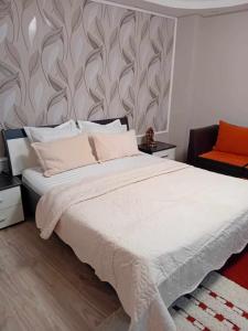 a bedroom with a large white bed and a chair at Casa Marco in Galaţi