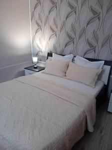 sypialnia z białym łóżkiem ze ścianą w obiekcie Casa Marco w mieście Gałacz