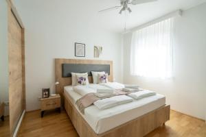a bedroom with a large bed with white sheets and a window at 1BR with Balcony, Urban Style by HM in Vienna