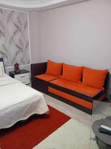 sypialnia z kanapą z pomarańczowymi poduszkami w obiekcie Casa Marco w mieście Gałacz