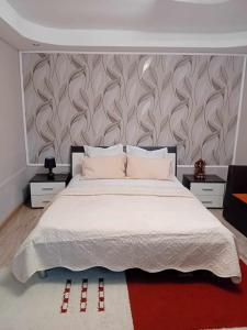 sypialnia z dużym białym łóżkiem i ścianą w obiekcie Casa Marco w mieście Gałacz