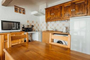 eine Küche mit einem Tisch, einer Mikrowelle und einem Kühlschrank in der Unterkunft Bon Nant furnished flat in Saint-Gervais-les-Bains