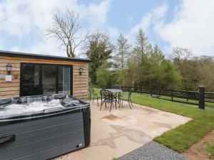 a patio with a hot tub and a table at Goldthorne Lodge in Kidderminster