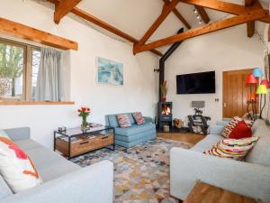 a living room with couches and a tv at The Stables in Camelford