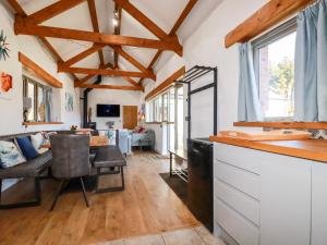 a kitchen and living room with wooden ceilings at The Stables in Camelford