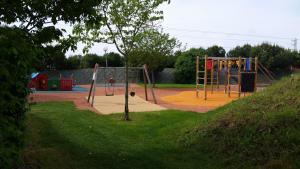 a park with a playground with two swings at Camping Le Beaulieu in Puilboreau