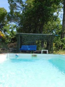 una piscina con sillas azules y un cenador en Bus-chambre à Chateaudouble en Châteaudouble