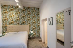 1 dormitorio con 2 camas y papel pintado con motivos florales en B&B Via Corsica 10 en Pisa