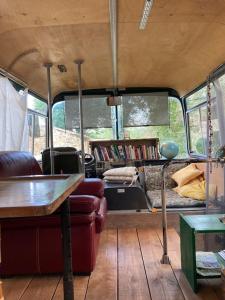 sala de estar con sofá y mesa en una furgoneta en Bus-chambre à Chateaudouble en Châteaudouble