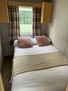Inglenook Caravan في Lamplugh: سرير في غرفة صغيرة مع نافذة