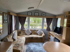 a living room with a couch and a table at Inglenook Caravan in Lamplugh