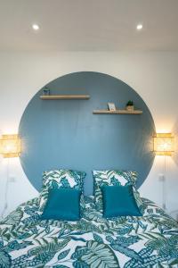 a bedroom with a bed with blue walls at Escapade Ocean in Labenne