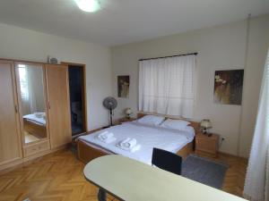 1 dormitorio con cama, mesa y escritorio en Apartmani Bon Bons, en Soko Banja